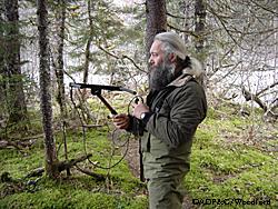 Beier uses a small VHF radio antenna and receiver to track a collared bear Photo by Riley Woodford