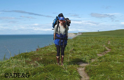 Kelly Hastings with a fully loaded pack on Tugidak Island High bluffs above the beaches allow researchers to monitor and study seals undisturbed