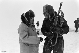 Marie Carroll prepares to leave the whales and return home to Barrow by snowmachine Geoff hands her a shotgun as bear protection Photo courtesy Bill Hess