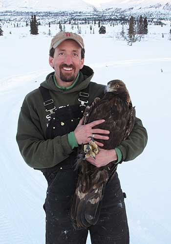 Biologist Travis Booms with an eagle prior to release