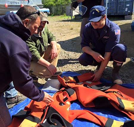 Coast Guard safety examiners check immersion suits in Bristol Bay in June 2015