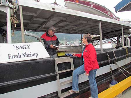 Petersburg fisherman Dennis Sperl sells to visitor Toni Portner aboard his boat the Saga Photo courtesy Toni Portner used with permission