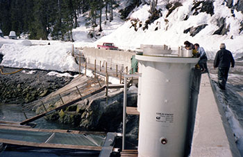 Snettisham Hatchery fish silos 1982 Both the silos and the incubators are ChemProof brand Below is a raceway divided into sections for rearing fish Sam Bertoni far right