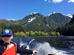 Figure 4. &mdash; Hugh Smith Lake, a crew member navigating the lake in summer sun.