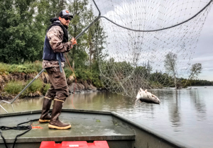 Photo of a fishermen with a large dip net.